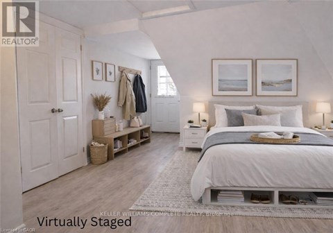 A bedroom with a bed, nightstands, and a coat rack.