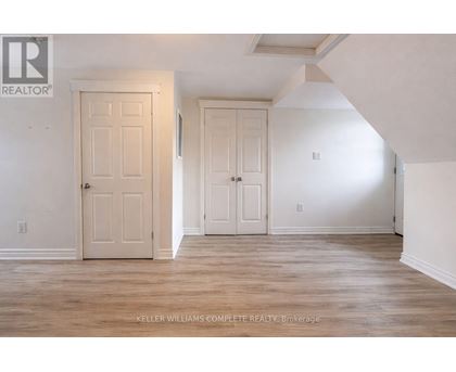 A room with two doors and a brokerage sign.
