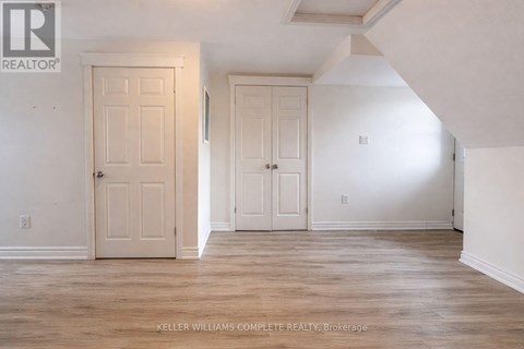 A room with two doors and a brokerage sign.