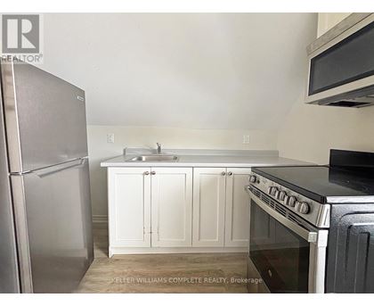 A kitchen with white cabinets and a stainless steel refrigerator.
