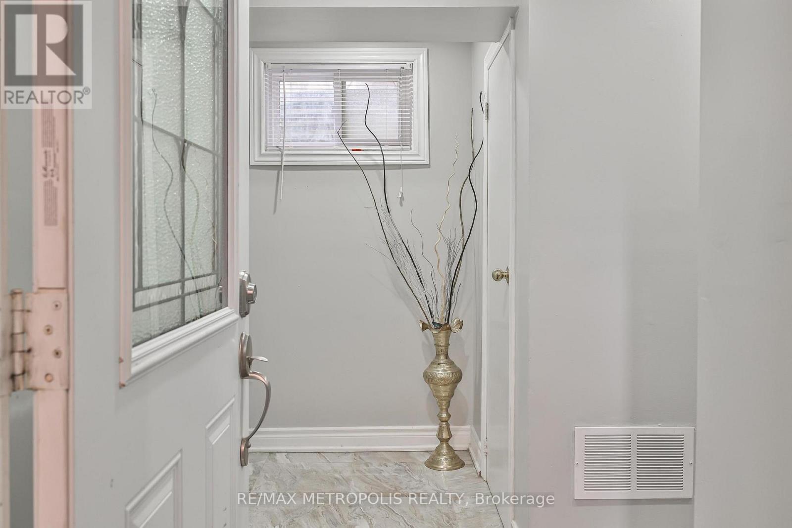 A hallway with a vase of dried flowers in the center.