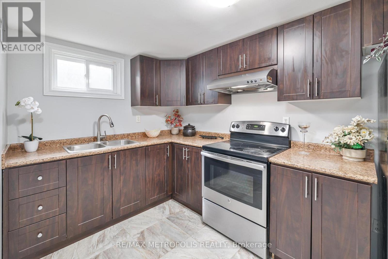 A kitchen with brown cabinets and a stainless steel oven.