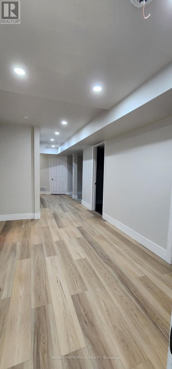 A long hallway with wood floors and white walls.