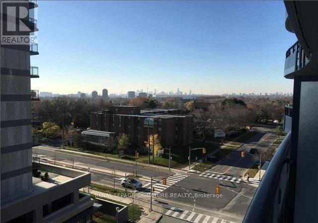 A view from a high-rise building looking out over a cityscape with a clear blue sky.
