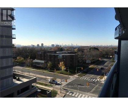 A view from a high-rise building looking out over a cityscape with a clear blue sky.