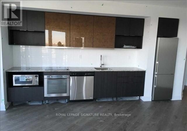 A modern kitchen with a sink, stove, and refrigerator.