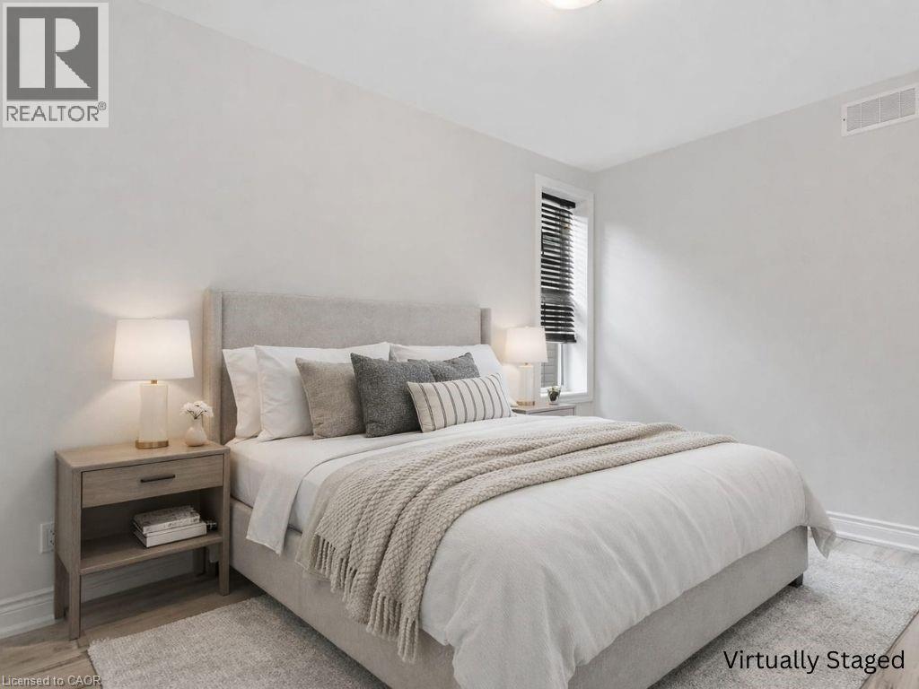 A bedroom with a bed, nightstand, and window.