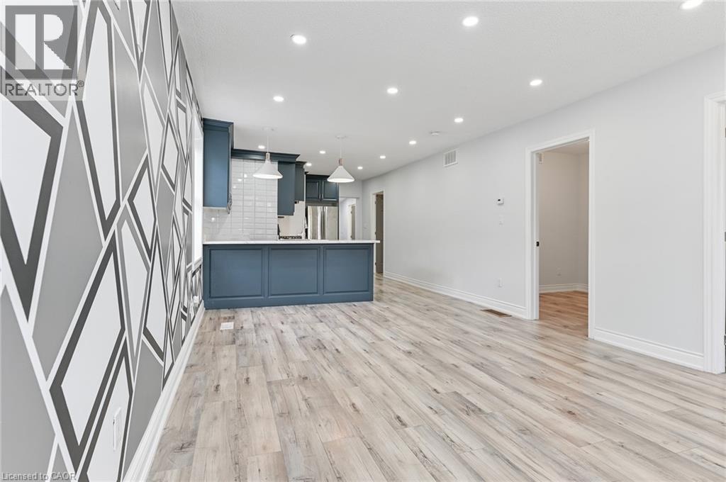 A spacious room with wooden flooring and a grey and white geometric patterned wall.