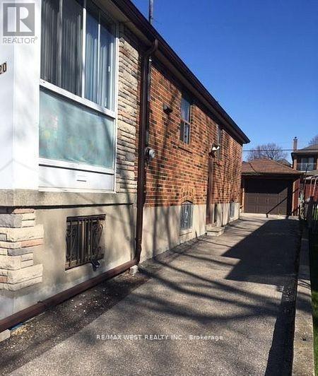 A long, narrow alleyway between two buildings with a Realty sign on the top left corner.