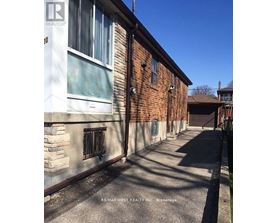 A long, narrow alleyway between two buildings with a Realty sign on the top left corner.