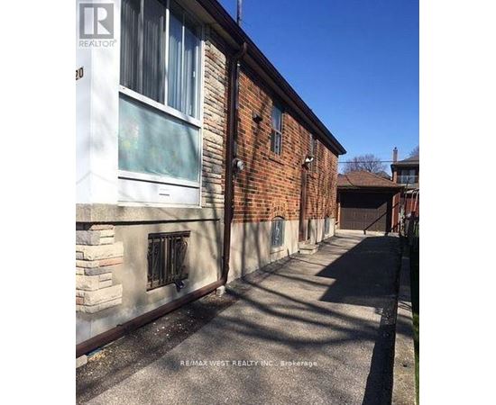 A long, narrow alleyway between two buildings with a Realty sign on the top left corner.