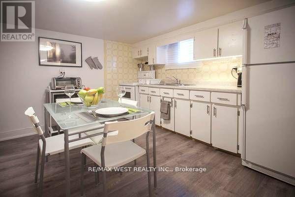 A kitchen with a table set for two with a brokerage sign in the corner.