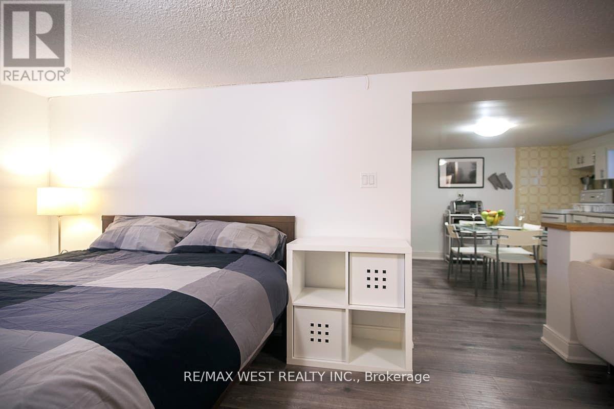 A bedroom with a bed and a small table with chairs in the other room.