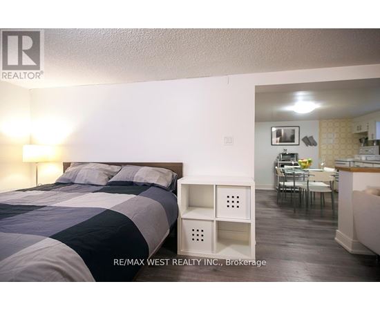 A bedroom with a bed and a small table with chairs in the other room.