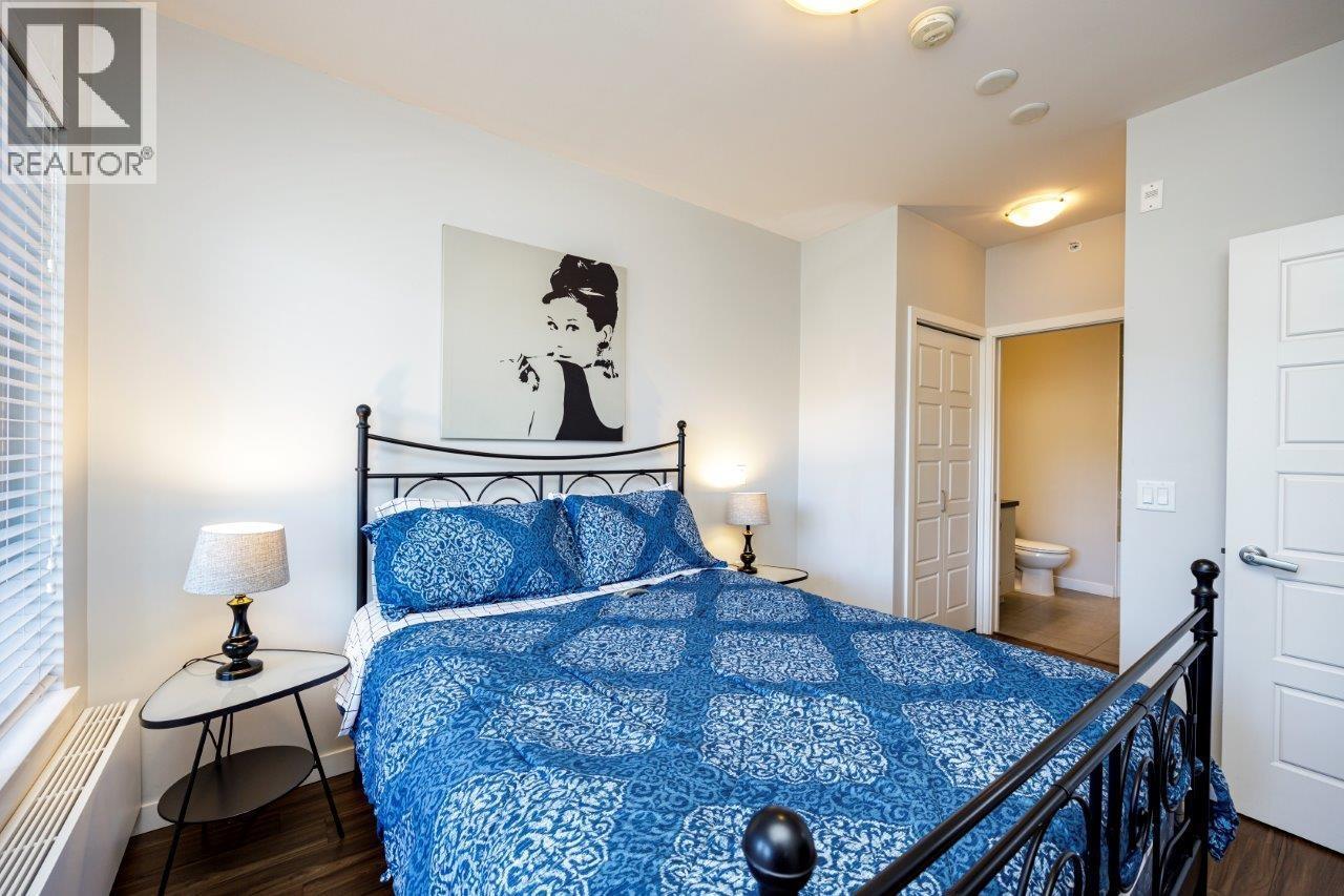A bedroom with a bed, a nightstand, and a painting on the wall.