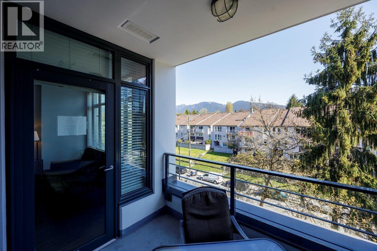 A balcony with a chair and a view of houses and trees.
