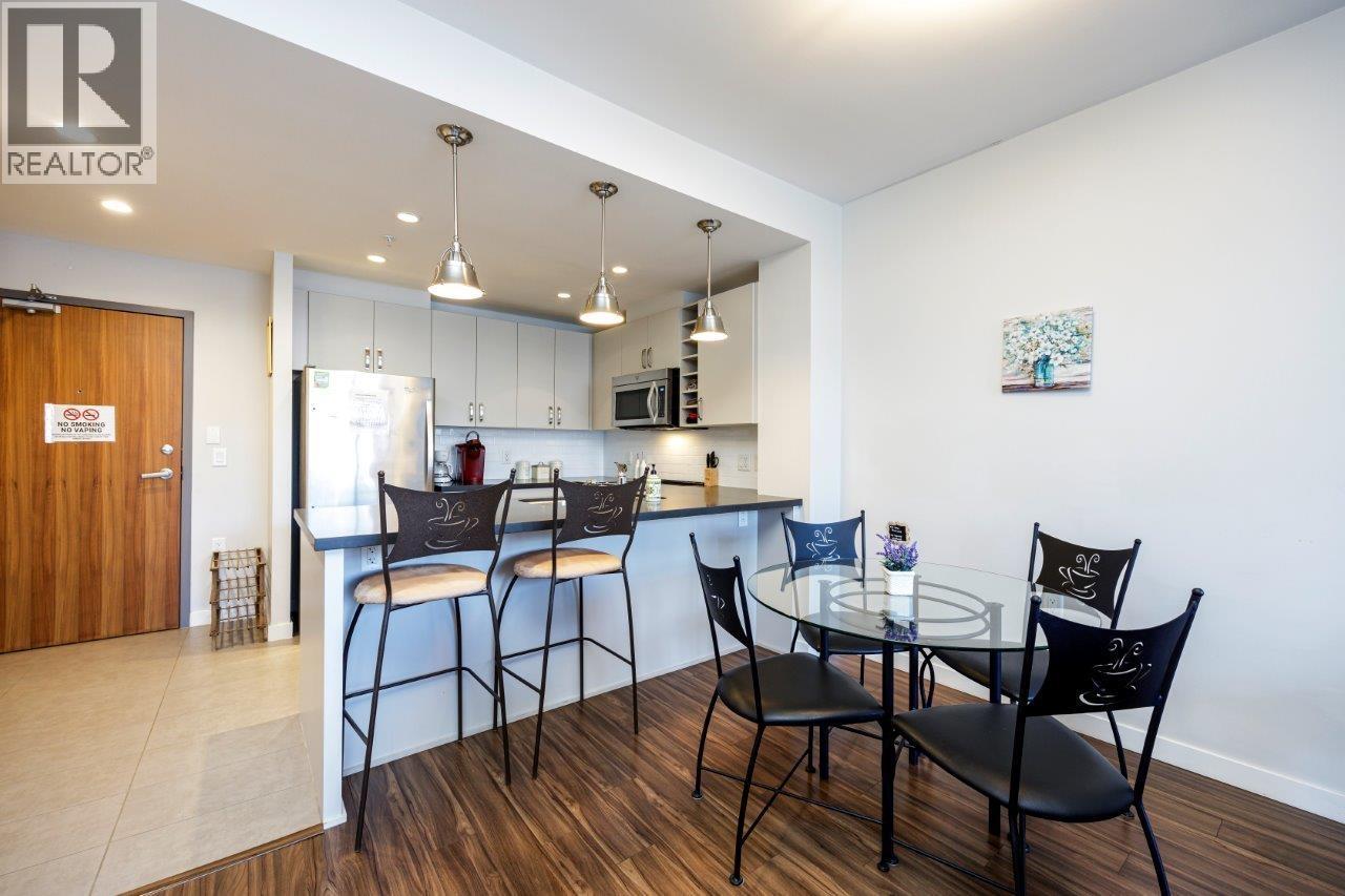 A modern kitchen with a dining table set for two.