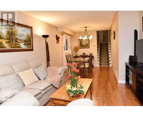 A living room with a couch, coffee table, and a painting on the wall.