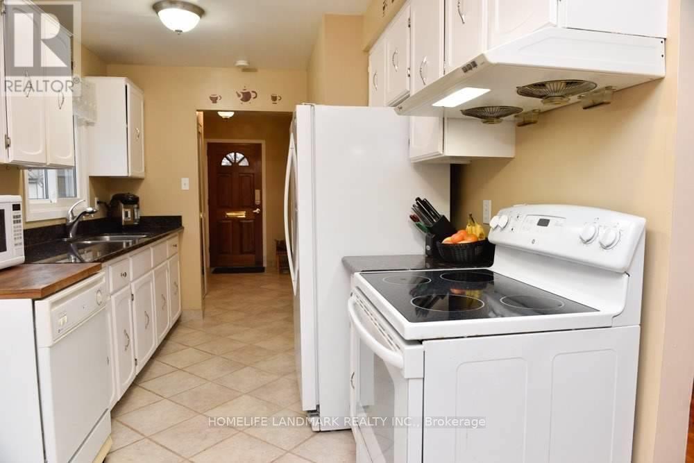 A kitchen with white appliances and cabinets.