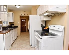 A kitchen with white appliances and cabinets.