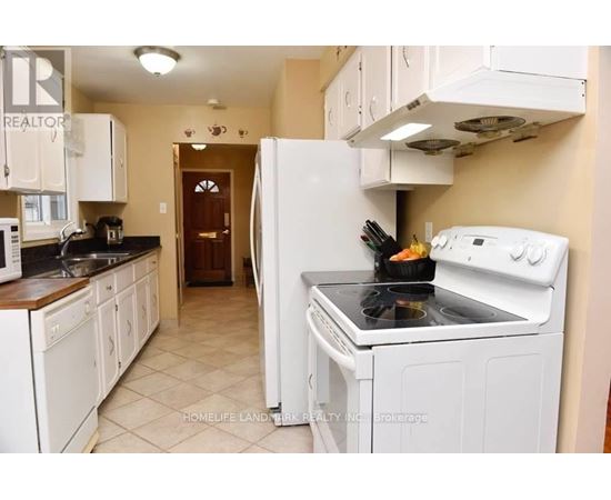 A kitchen with white appliances and cabinets.