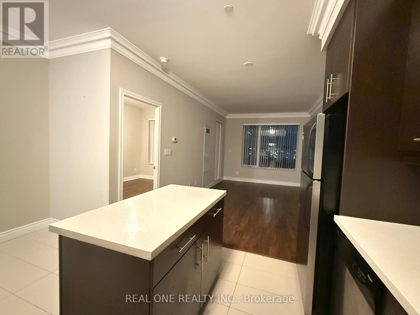 A kitchen with dark wood cabinets and a white countertop.