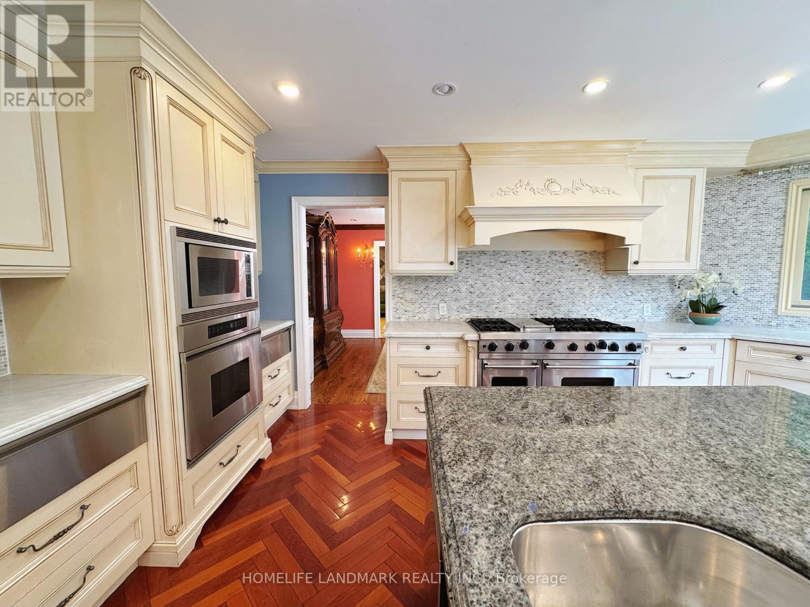 A kitchen with a granite counter top and stainless steel appliances.