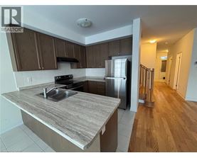 A kitchen with a refrigerator, sink, and stove.