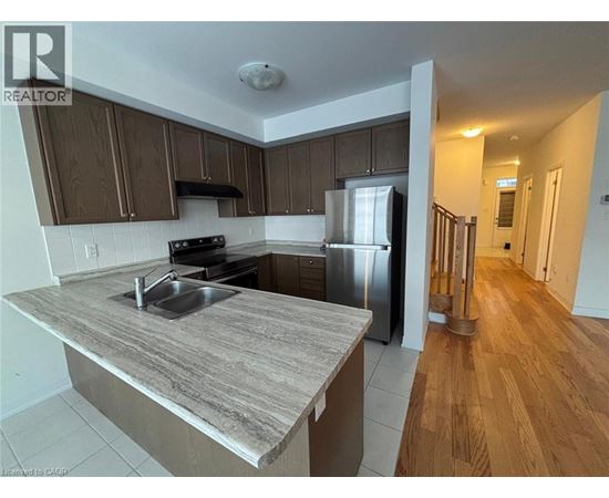 A kitchen with a refrigerator, sink, and stove.