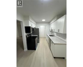 A kitchen with white cabinets and a grey counter top.