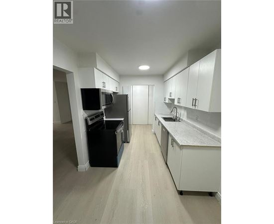 A kitchen with white cabinets and a grey counter top.