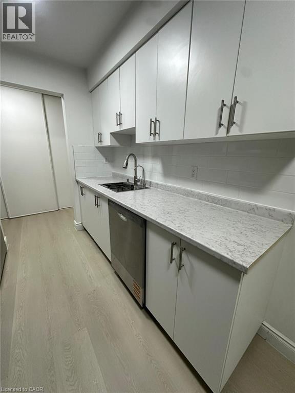 A long hallway with a refrigerator on the left.