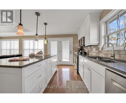 A kitchen with white cabinets and a wooden floor.
