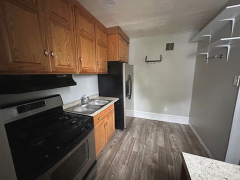 A kitchen with wooden cabinets and black appliances.