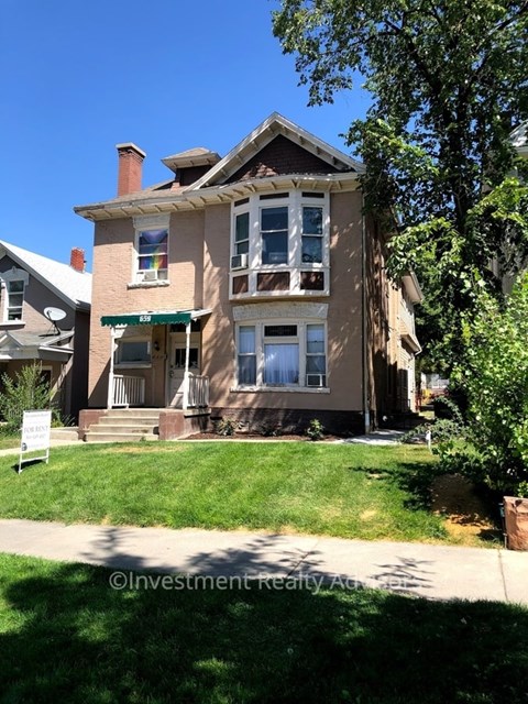 A two-story house with a green lawn in front.