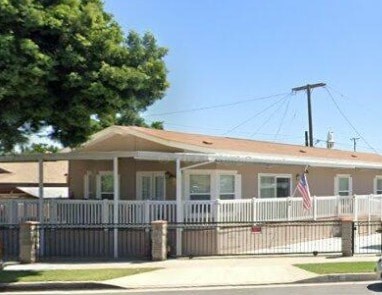 A house with a white picket fence and an American flag on it.