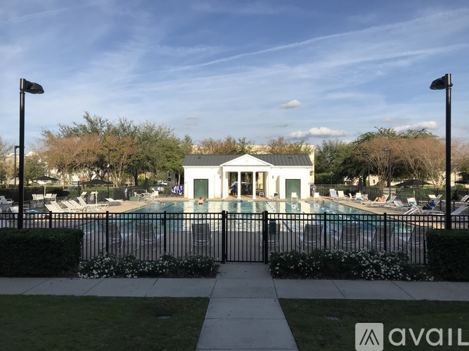 A pool area with a fence and a building in the background.