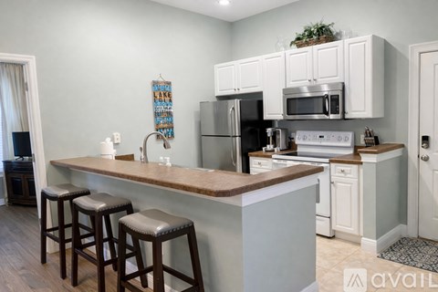 A kitchen with white cabinets and a wooden island.