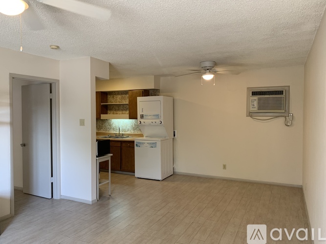A kitchen area with a refrigerator, sink, and cabinets.