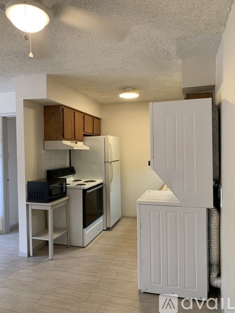 A kitchen with a white refrigerator and a microwave oven.