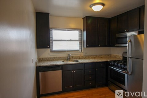 A kitchen with black cabinets and stainless steel appliances.