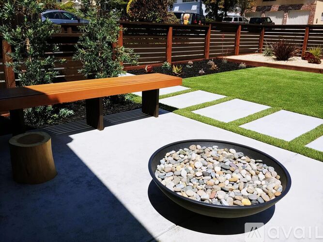 A black bowl filled with rocks sits on a white square mat.