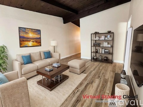A living room with a painting on the wall and a coffee table in the middle.