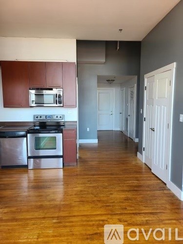 A kitchen with wooden floors and a stove top oven.