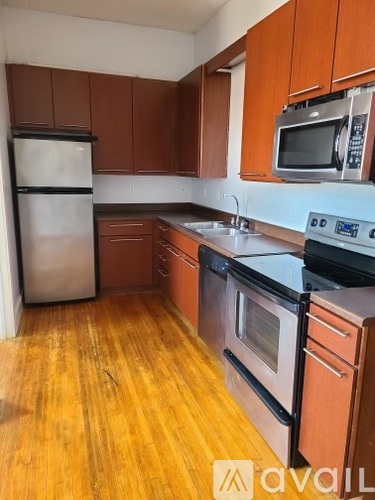 A kitchen with wooden floors and a refrigerator.