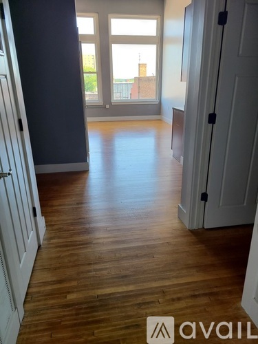 A room with wooden floors and white doors.