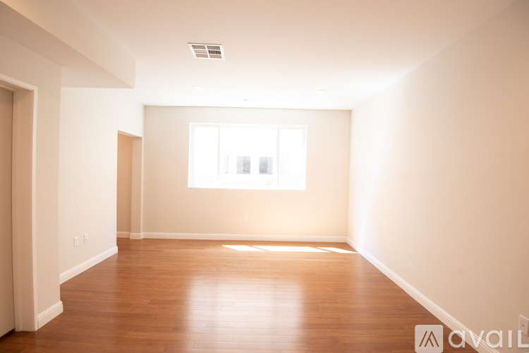 A spacious room with wooden floors and a window.