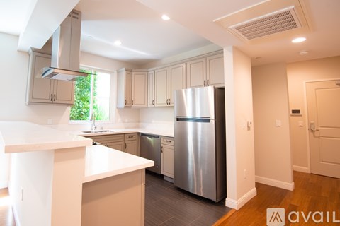 A kitchen with a stainless steel refrigerator and a white countertop.