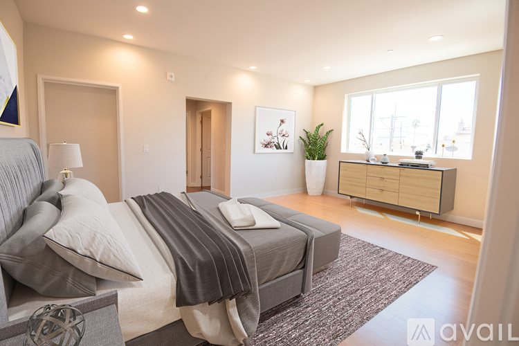 A bedroom with a large bed and a dresser with a mirror.