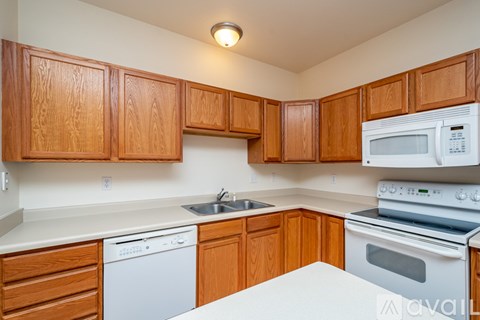 A kitchen with wooden cabinets and white appliances.